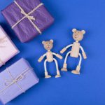 Happy Father's Day background. Greeting card with family of wooden teddy bears toy and gift box on blue background. Flat lay. Copy space.